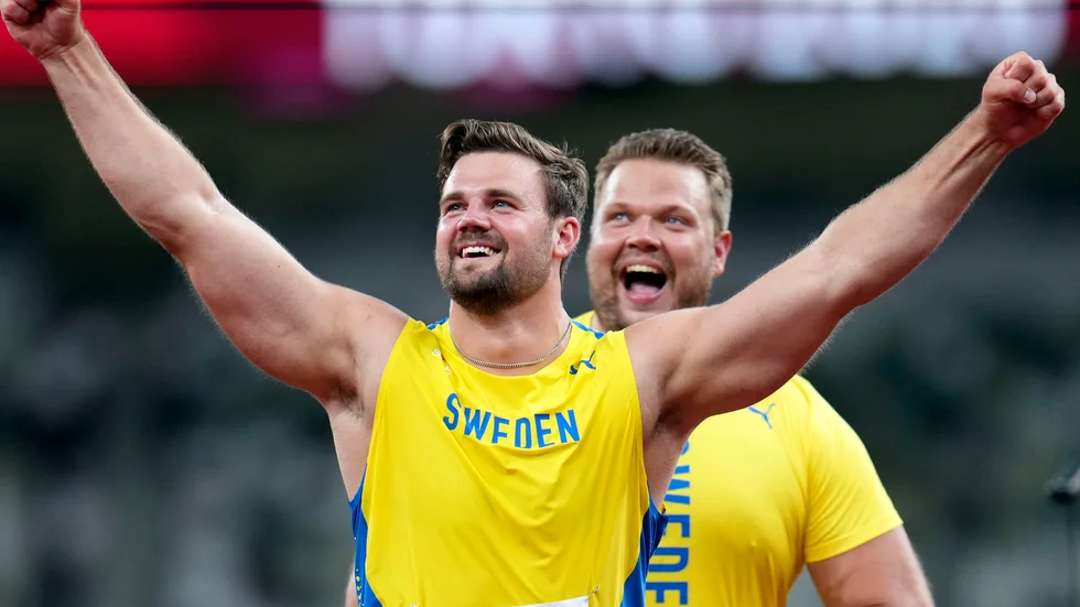 Simon Pettersson jublar över sitt OS-silver. Bakom är guldmedaljören Daniel Ståhl. 