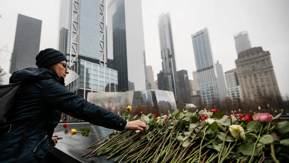 Anhöriga placerar blommor vid ett minnesmonument för terrorns offer på den plats där World Trade Center en gång stod i New York.