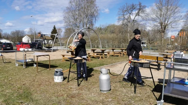 Kockarna Sara Sörberg och Katarina Söderberg lagar mat utomhus.