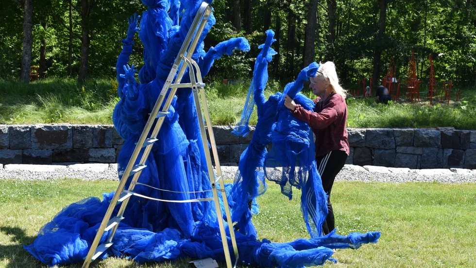 Eva Högberg monterar sin skulptur "Det blå trädet". 