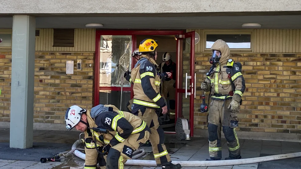 Rökdykare från räddningstjänsten söker igenom lägheten för att säkerställa att den är tom.