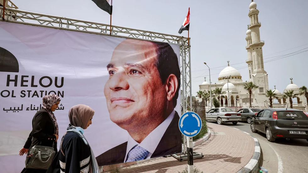 Palestinier går förbi en av de jättebilder av Egyptens president Abd al-Fattah al-Sisi som sattes upp i Gaza City i helgen.