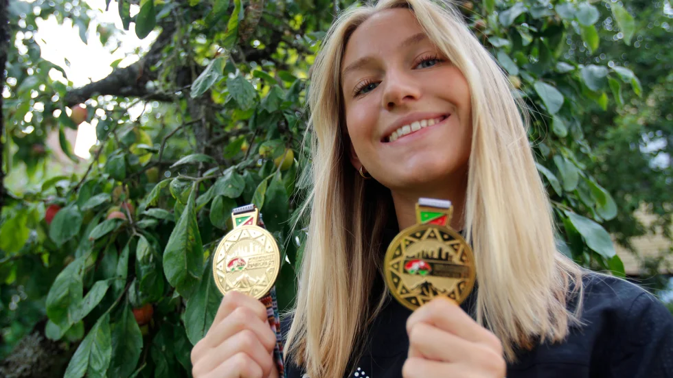 18-åriga Maja Åskag visar stolt upp guldmedaljerna hon tog under JVM förra helgen. På lördag 12.35 gör hon entré på SM när längdhoppstävlingen drar igång.