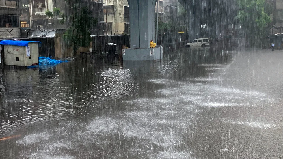 Ett hus rasade och gator och torg fylldes med vatten när monsunen drog in över staden Bombay (Mumbai) under onsdagen.