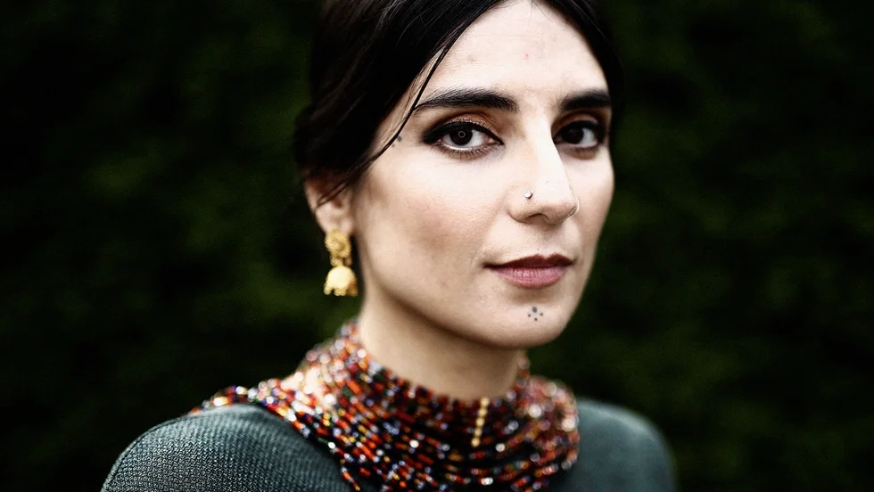 Balsam Karam är född i Iran men bor sedan barnsben i Stockholm där hon arbetar som bibliotekarie. Hon debuterade 2018 med den uppmärksammade romanen "Händelsehorisonten".