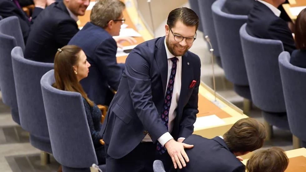 Jimmie Åkesson i glatt samspråk med en av sina riksdagsledamöter i samband med voteringen om statsminister.