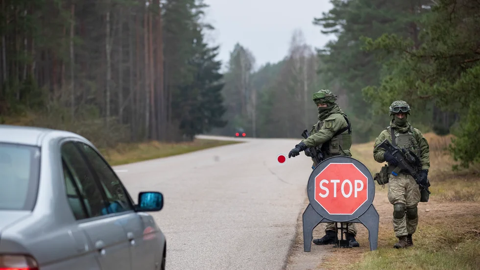 Litauisk militär kontrollerar bilar på en väg nära gränsen till Belarus i byn Jaskonys.