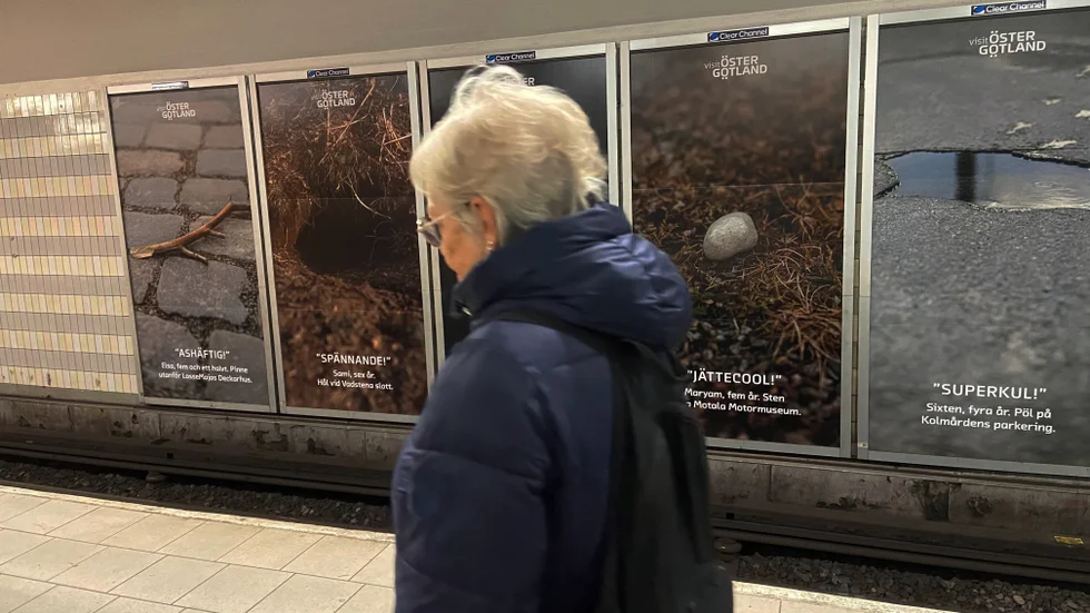 Där, på väggen bakom damen, skymtar Visit Östergötland reklamkampanj. Långtifrån alla hinner upptäcka budskapet.