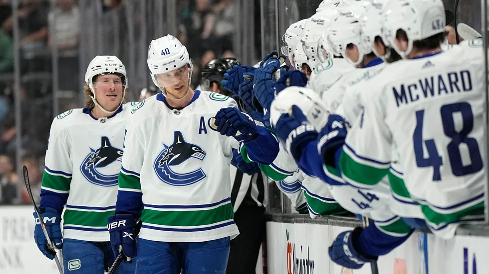 Vancouvers Elias Pettersson firar 100:e poängen med laget och följs av målskytten Brock Boeser.