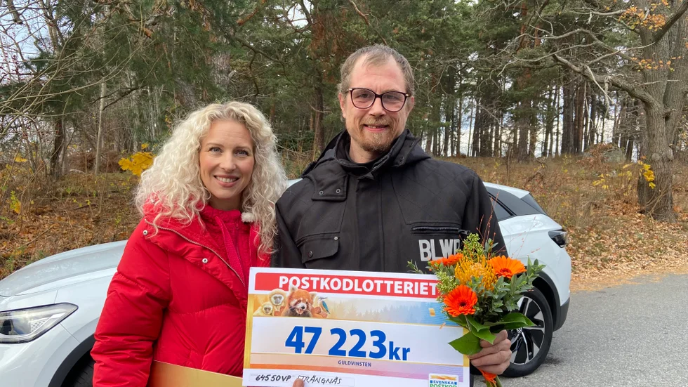 Sandra Dahlberg tillsammans med vinnaren Mika Oja. Bakom står den nya elbilen han precis vunnit, utöver prispengarna i handen.