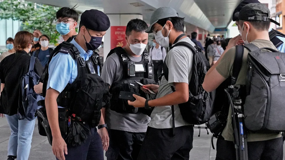 Polis i Hongkong stoppar journalister för att kontroll inför regionalt regeringsbyte i somras. Arkivbild.