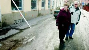 Foto: ANDERS LILJEGREN "Ja, här låg vi och kravlade i lördags", säger Barbro Holmberg. Hon och maken Ingemar Holmberg är kritiska till att fastighetsägare spärrar av trottoarer där det är risk för snöras och istappar.  Då tvingas fotgängarna ut i gatan i stället, och där är det fullt av svallis. I lördags var det dessutom nysnö ovanpå, så det var rejält halt, intygar Ingemar Holmberg.