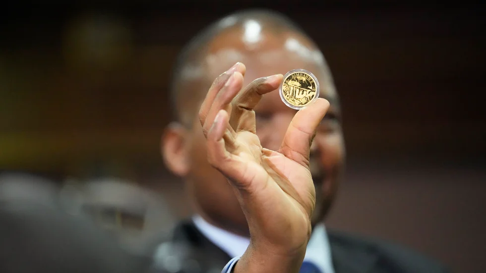 Centralbankschefen John Mangudya visar upp de nya guldmynten i Harare. Bilden är från lanseringen i juli.