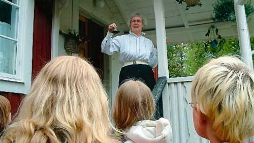 Lärarinnan Inger Falk ringer in eleverna för en lektion i 1940-talets skola. Foto: Lars-Göran Bexell