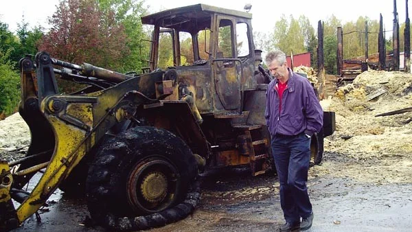Bo Johansson från Vimmerbypolisen inspekterar den lastmaskin som var orsaken till storbranden vid Hyltahus sågverk i Rumskulla på måndagskvällen, då värden för en miljon kronor blev lågornas rov.