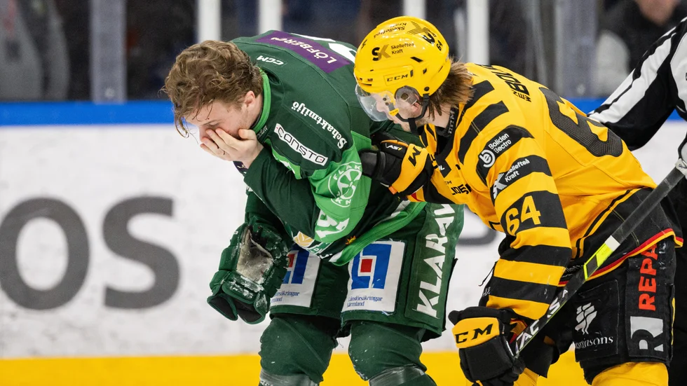 Jonathan Pudas hjälper Adam Ginning efter att Färjestadsbacken skurits i ansiktet av en skridskoskena.