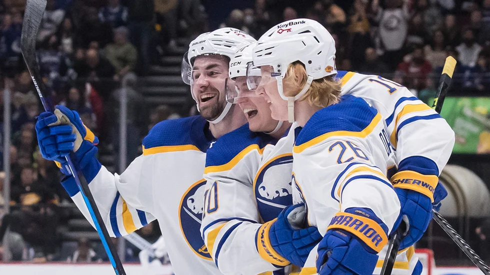Buffalos Rasmus Dahlin (till höger) kramas om av Henri Jokiharju (mitten) och Mattias Samuelsson efter sitt segermål.