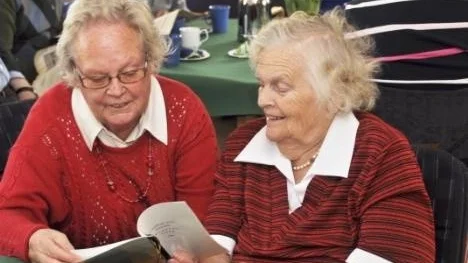 Från vänster Bibbi Johnsson och Greta Ström läser höstens program på invigningen av anhörigcentrum i Östhammar.