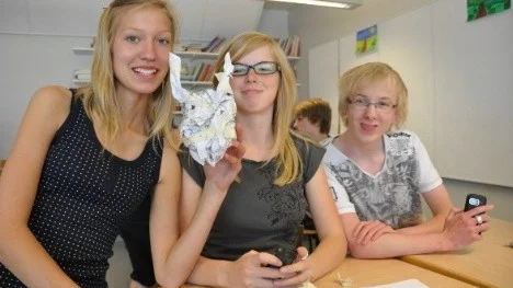 Amanda Engman, Linnea Kjellberg och Alexander Sundin formar ett djävulsliknande huvud för att visa vad boken Blåögd av Mats Berggren handlar om.