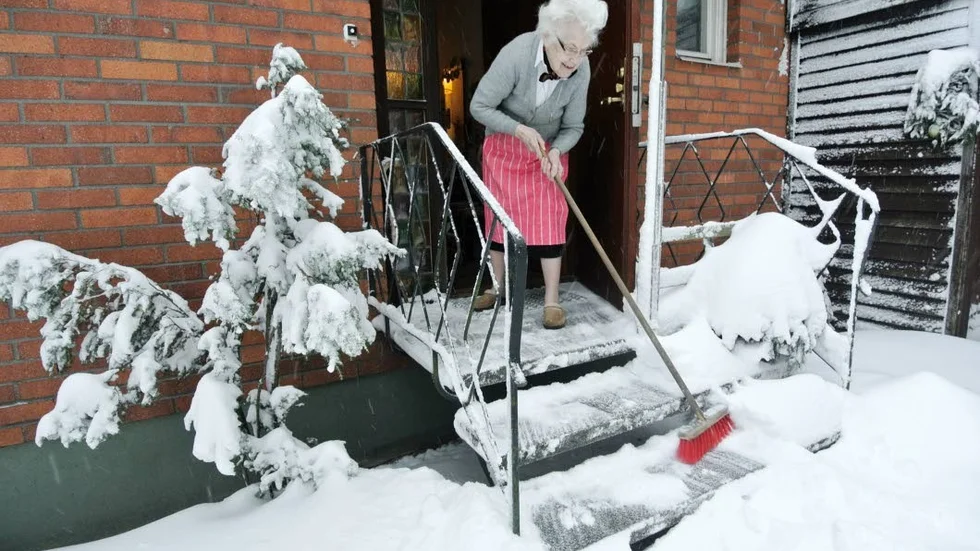 Soprent.  Marianne Wenngren på Kyrkogatan i Tierp, klarar snön på trappen men tar sig inte genom plogkanten ut på trottoaren.