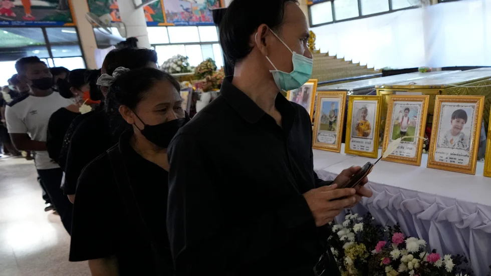 Sörjande vid templet Wat Rat Samakee hedrar offren för massakern i norra Thailand.