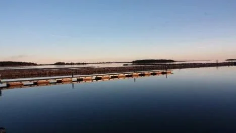 Båtbryggan vid Havsbadet ligger övergiven. Inte en krusning stör vattenytan.