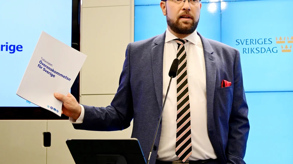 Sverigedemokraternas partiledare Jimmie Åkesson (SD) med överenskommelsen i handen vid gemensam pressträff, i riksdagens presscenter, om regeringsbildningen.