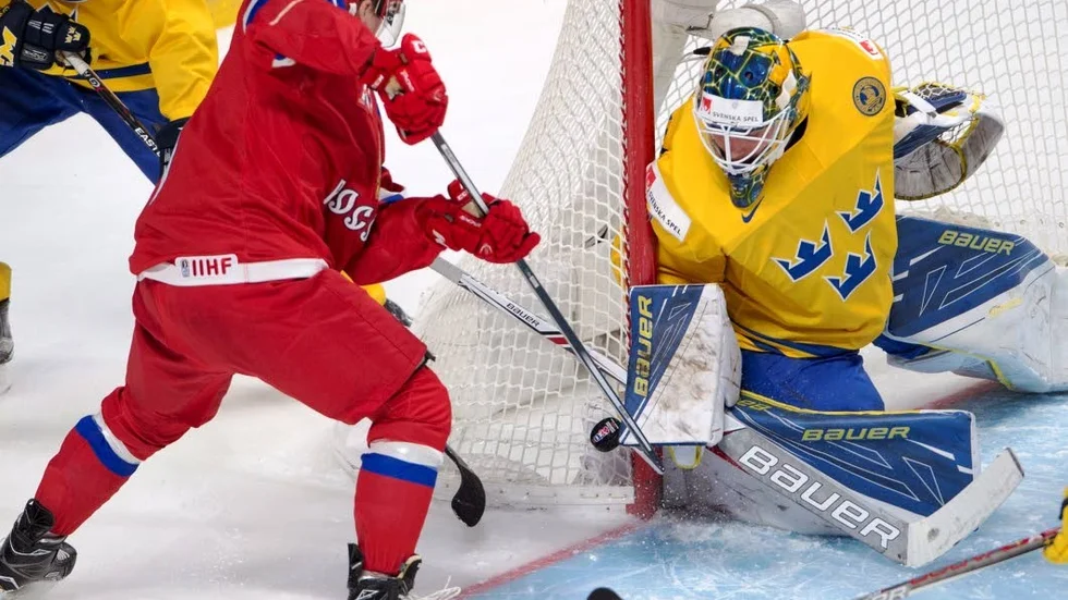 Russia's Kirill Kaprizov (7) tries to jam in a loose puck on Sweden's goaltender Felix Sandstrom (1) during the first period of the bronze medal game at the World Junior ice hockey championships, Thursday, Jan. 5, 2017 in Montreal. (Ryan Remiorz/The Canadian Press via AP)