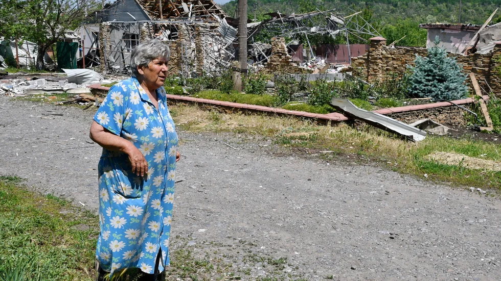 En kvinna går förbi byggnader som anfallits i Slovjansk, nära Kramatorsk i östra Ukraina, på onsdagen.