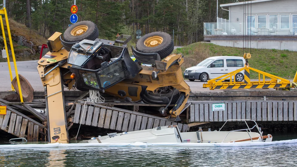 En kranbil välte, sänkte segelbåten den skulle sjösätta och förstörde delar av motorbåtklubbens brygga.