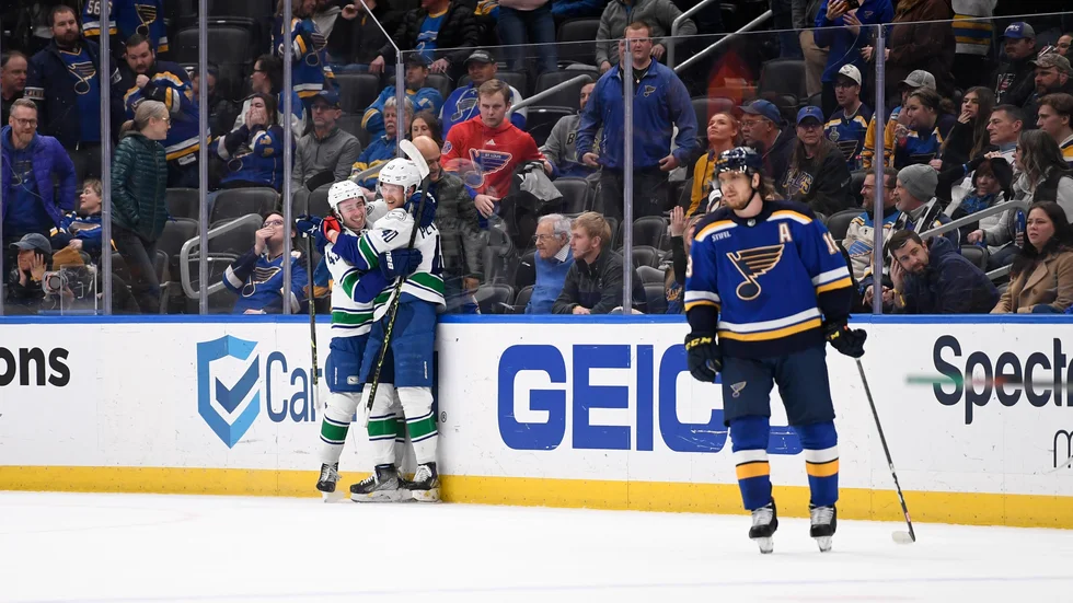Elias Pettersson, i mitten, kramas om av lagkamraten Quinn Hughes efter sitt segermål i förlängningen mot St Louis.