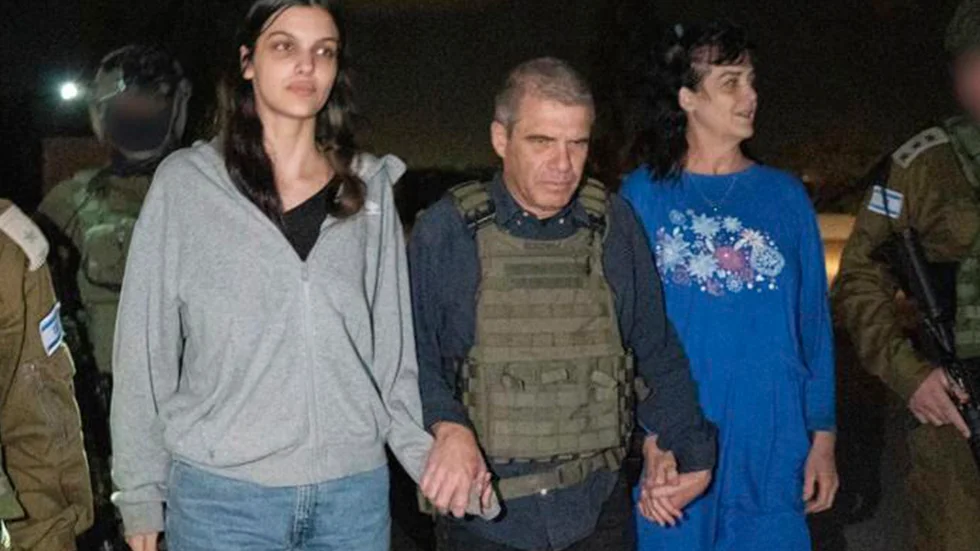 På bilden, som tillhandahållits av Israels regering, syns 17-åriga Natalie Raanan och hennes mamma Judith Raanan när de eskorteras av en israelisk soldat vid sin återkomst till Israel på fredagskvällen.