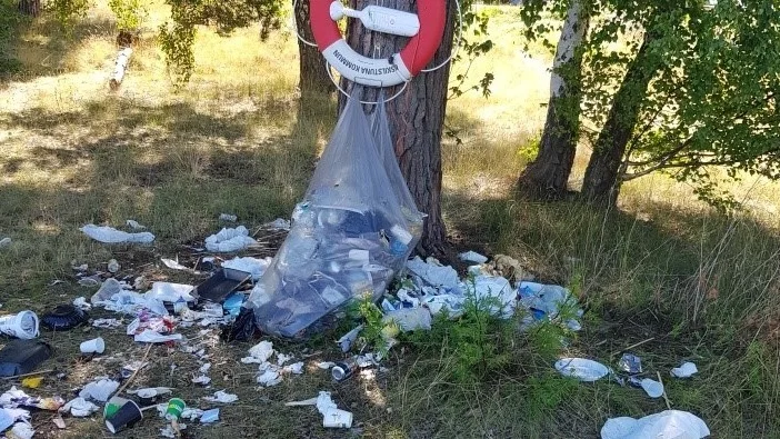 Det här sopberget befinner sig precis bredvid grillplatsen på Hjälmaresunds badplats. Men frågan är vems ansvar det är att städa upp det.