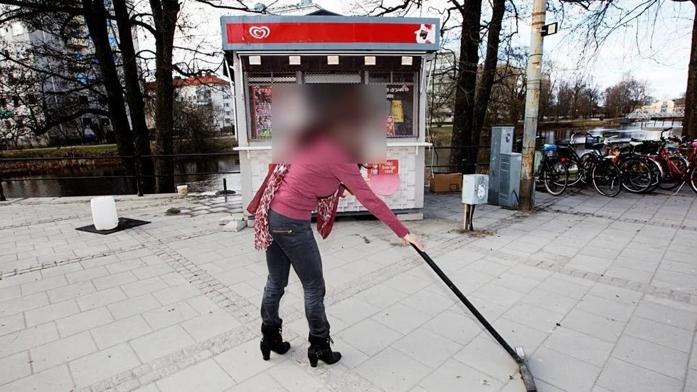 Rävens mamma, som är dömd för penningtvätt i samband med sonens affärer, sopar framför glasskiosken. Bilden togs för några år sedan i samband med en artikel om vårens ankomst i Uppsala. 