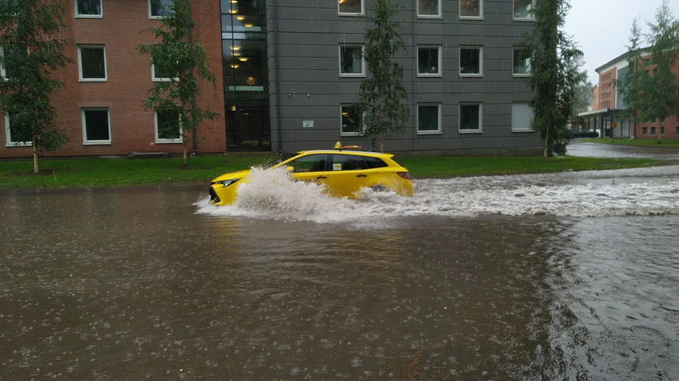 Översvämmade Mjölkudden. Himlen öppnade upp sig i Luleå och på Mjölkudden samlades stora mängder vatten på vägen. Vesa Avaskari fotograferade en taxibil som plöjde fram i vätan.