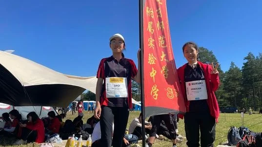 Jiaqi Lui och Minxian Liu från Beijing normal universitetet med skolans flagga.