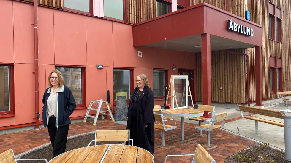 Thina Berg och Charlotte Wiklund Karlsson utanför nya särskilda boendet. Precis vid entrén finns utemöbler och planteringar.