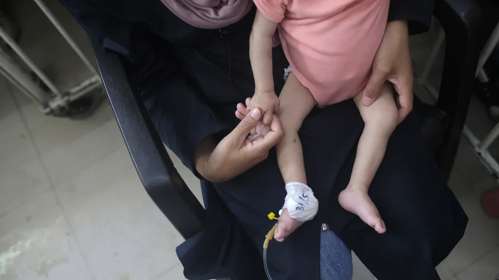 En mamma och hennes tio månader gamla son, som lider av undernäring, i Gaza. Foto från tidigare i juni.
