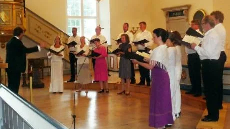 Eric Ericssons Kammarkör avrundade en sommarturné med en finalkonsert i Gamleby kyrka på söndagskvällen. Till vänster gästdirigenten Fredrik Malmberg.