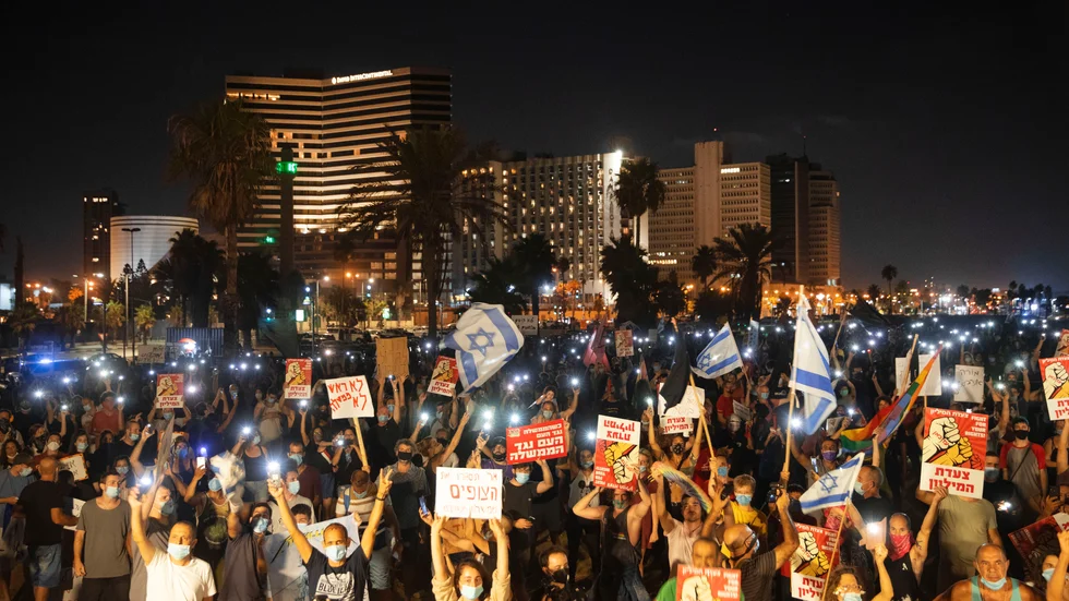 Demonstranter iförda skyddsmasker under lördagens demonstration i Tel Aviv.