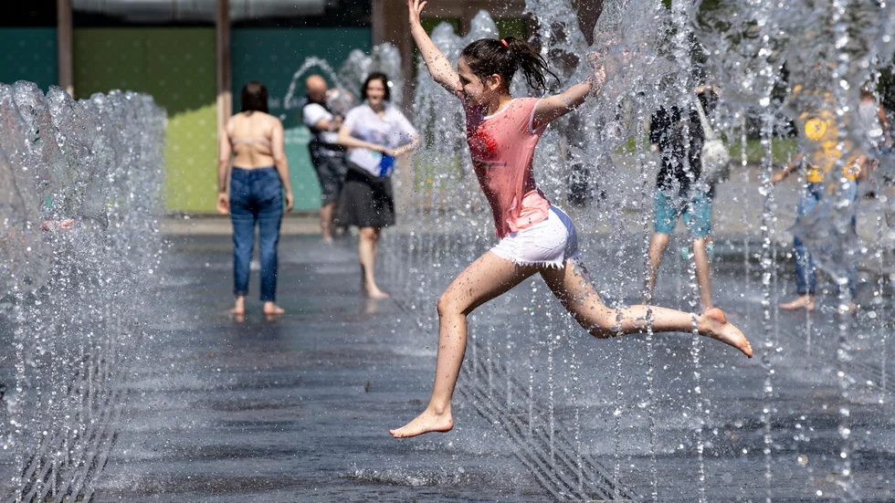 Ett barn svalkar sig i en fontän i Rysslands huvudstad Moskva den 11 juni, när temperaturen låg kring 30 grader.