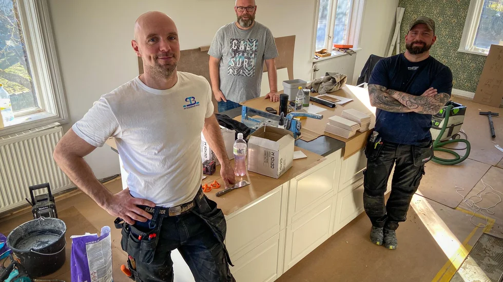 Hantverkarna Henrik Enerbrant och Linus Vallin framför köksön hemma hos Andreas Key som står bakom densamma. Renoveringslustan har ökat i hela landet, inte minst i Flens kommun.