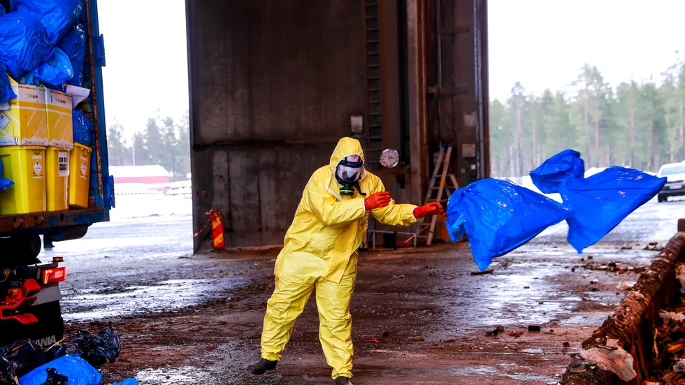 Den anställde från Veolia fick även hjälpa till att få bort de första säckarna som föll ur containertransporten när dörren öppnades.