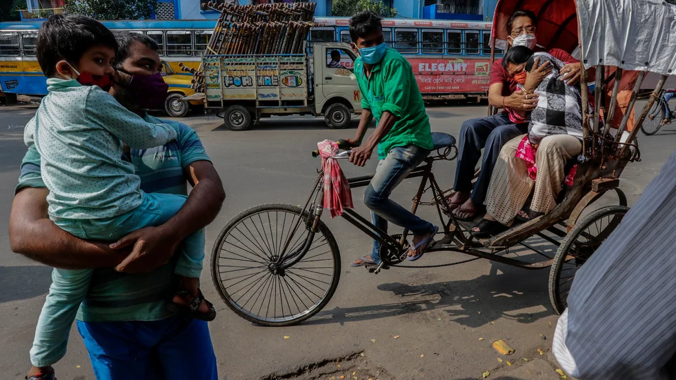 En familj med munskydd i Calcutta i nordöstra Indien i slutet av november.