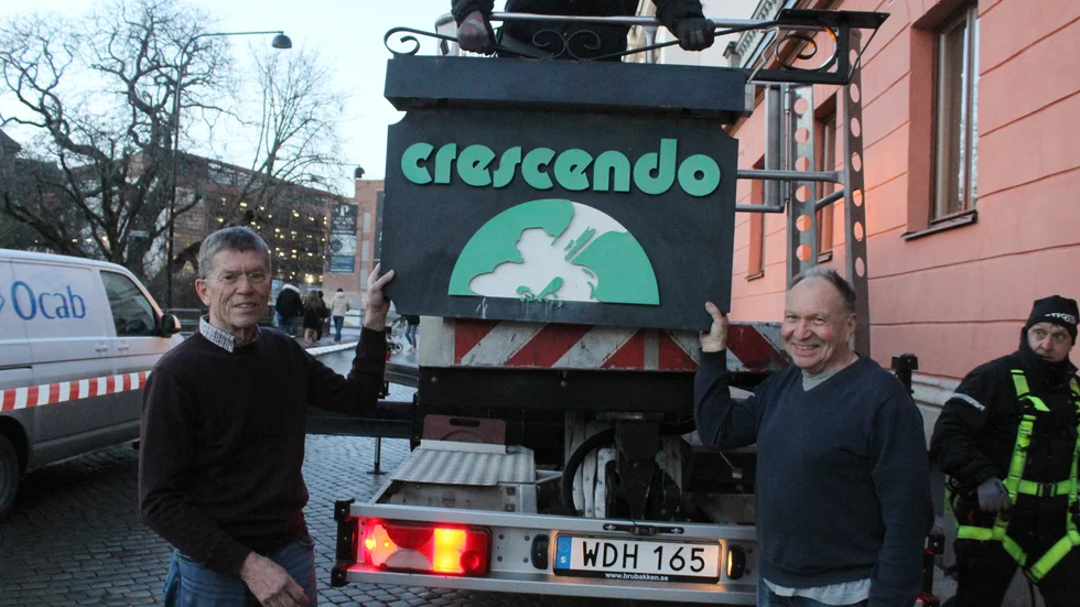Crescendos välkända föreningsskylt plockades nyligen ner från fasaden på Järnbrogatan. Göran Törner och Roger Lindberg från styrelsen tar emot skylten.