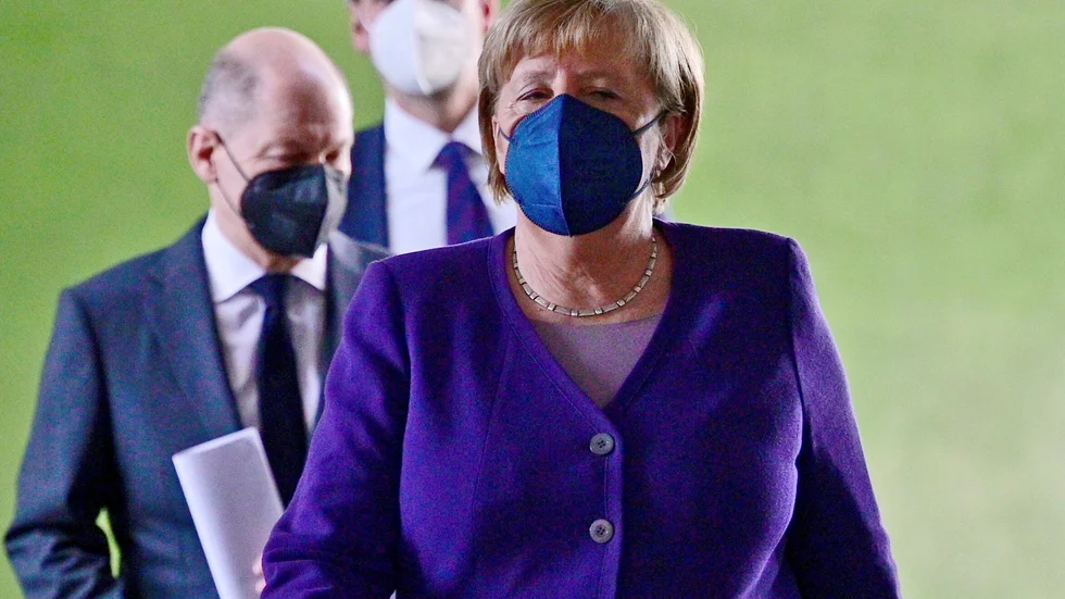 Tysklands avgående förbundskansler Angela Merkel, med tillträdande förbundskansler Olaf Scholz strax bakom, har i samråd med förbundsländernas ledare beslutat att skärpa kraven om vaccinering.