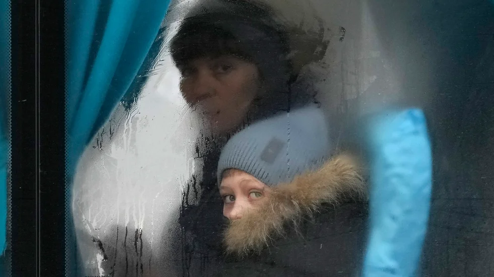 En kvinna och ett barn som flyr från regionen Luhansk i östra Ukraina, efter Rysslands invasion av landet.
