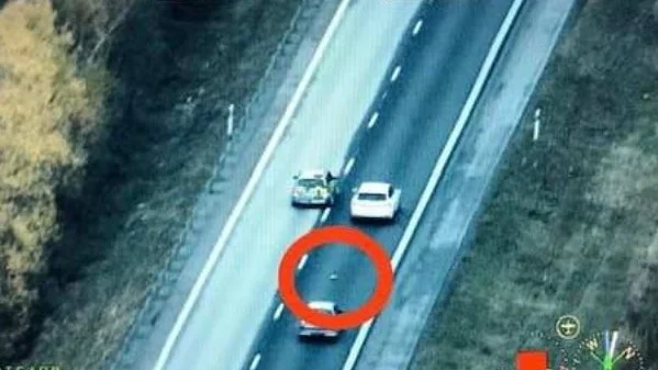 På E18 kastade männen ut påsen med nästan ett kilo amfetamin. De filmades av polisens helikopter.