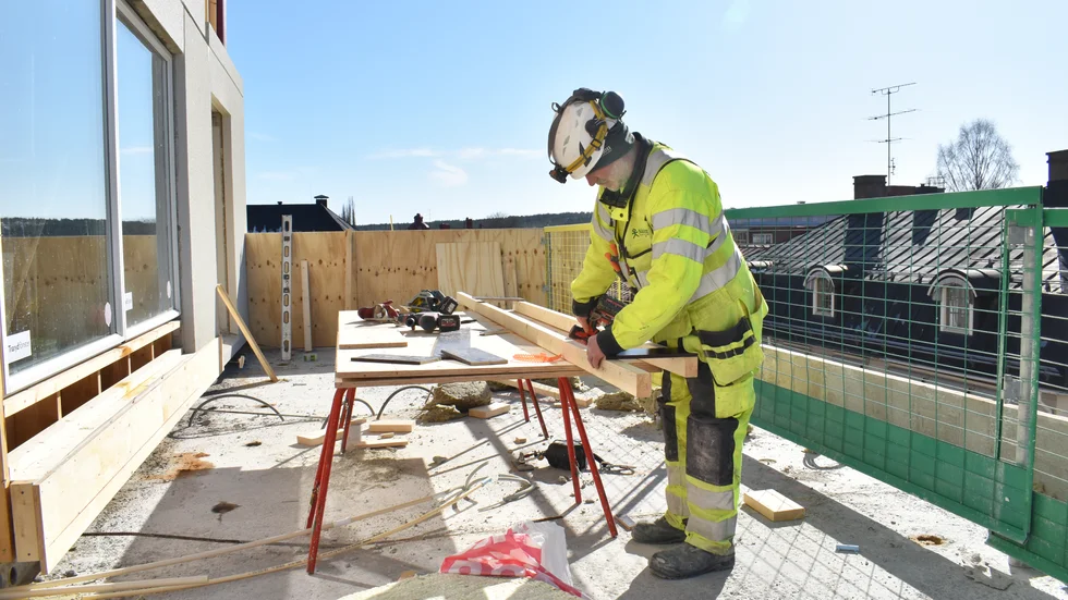 Solen skiner över Skellefteå och Fredrik Rundqvist gör räcken till en uteplats. Här ska folk njuta som har köpt en lägenhet i Höderskrapan.