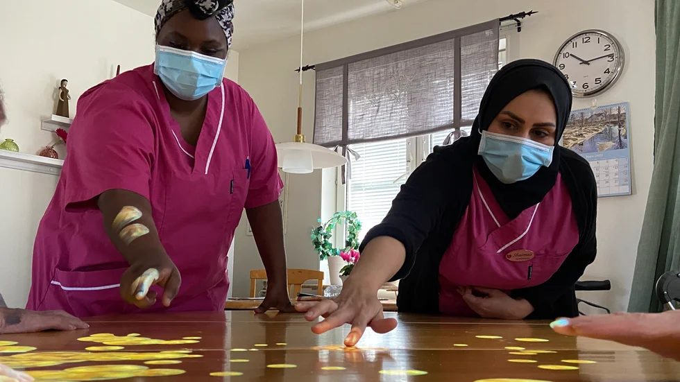 Deka Farah Ali och Shaimaa Ali visar hur ett av de fiktiva spelet fungerar. Bordet fylls med bubblor. När man petar på dem spricker de. 
